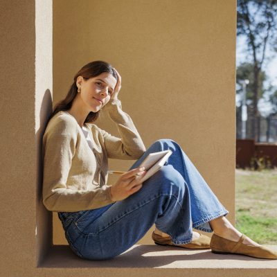Young woman sitting outdoors writing notes in a notebook at a sustainable house Young woman sitting outdoors writing notes in a notebook at a sustainable house model released, Symbolfoto property released, EBIF00153